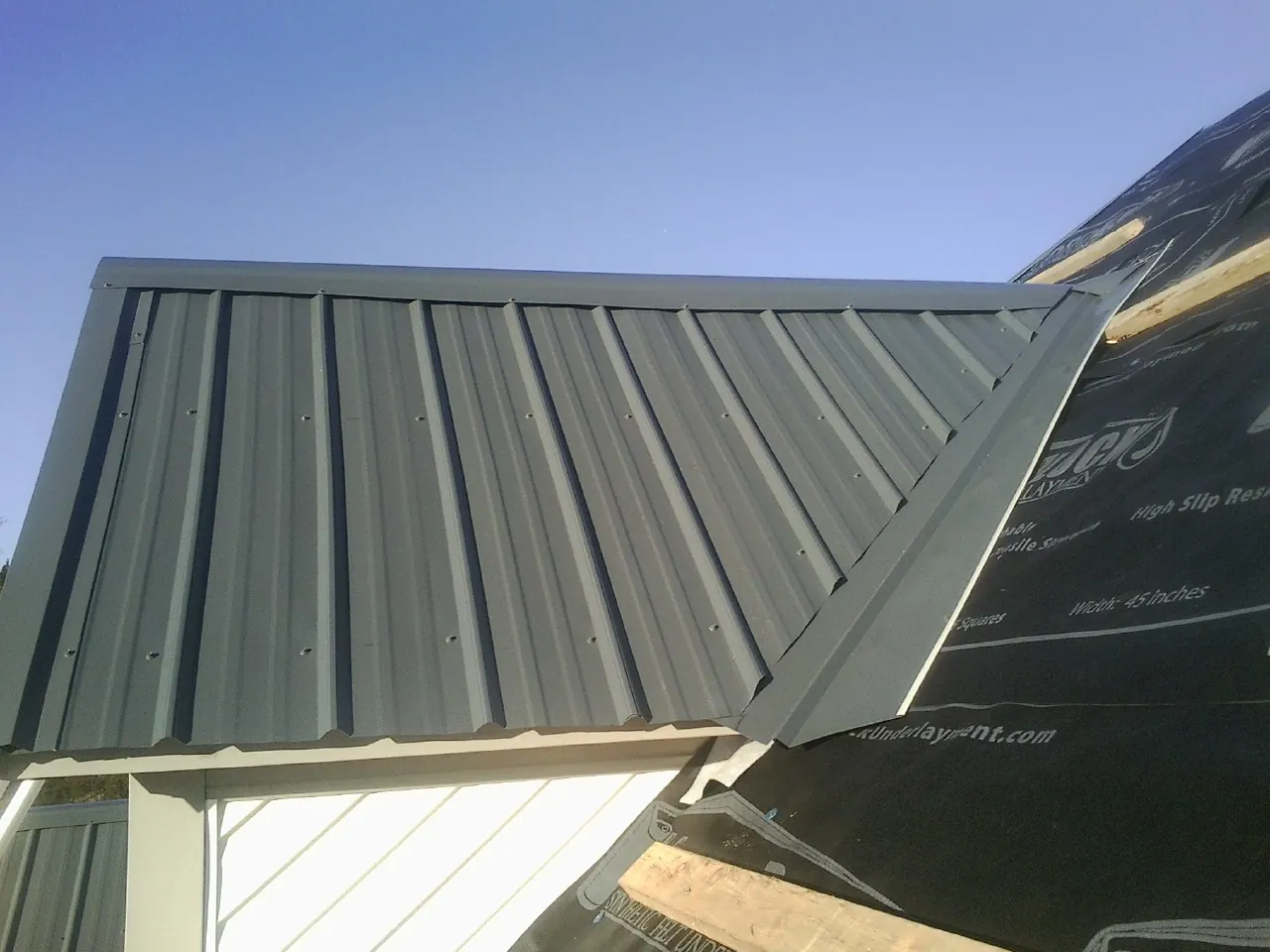 Gray metal roof panels going on over a garage gable in Middletown